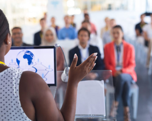 Rear,View,Of,Pretty,African-american,Female,Speaker,Giving,Speech,To